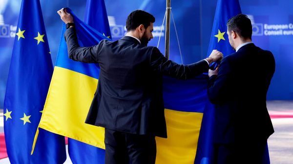 Сотрудники протокольной службы устанавливают флаг Украины перед саммитом ЕС в здании Европейского совета в Брюсселе. Сотрудники протокольной службы устанавливают флаг Украины перед саммитом ЕС в здании Европейского совета в Брюсселе. - Sputnik Таджикистан