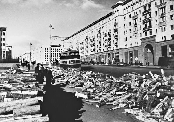  Прифронтовая Москва готовится к зиме. Заготовленные на зиму дрова на улице Горького. На дороге - троллейбус ЯТБ-3. - Sputnik Таджикистан