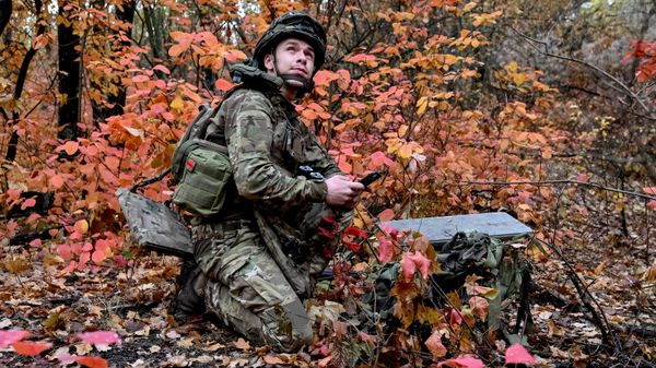 Украинский военнослужащий устанавливает систему спутникового интернета Starlink на позиции недалеко от линии фронта в Донецкой области 16 октября 2026 года. - Sputnik Таджикистан