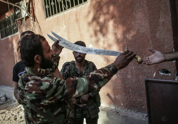 Солдаты держат меч, которым боевики вершили шариатское правосудие в сирийском городе Гута. Архивное фото - Sputnik Таджикистан