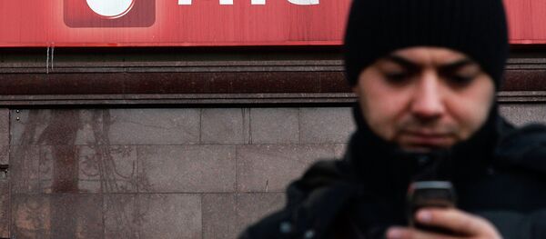 Мужчина с телефоном стоит у офиса компании оператора мобильной связи МТС, архивное фото - Sputnik Таджикистан