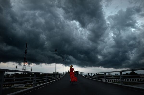 Девушка бежит по пешеходному мосту в Великом Новгороде. - Sputnik Таджикистан