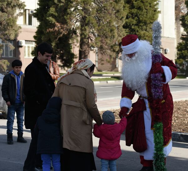 Человек в костюме Деда Мороза на площади Дусти - Sputnik Таджикистан