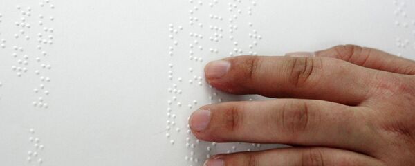 Марсел Гайфуллин, интихобкунандаи нобино варақаи тарғиботии интихоботи президентиро дар маҳалли интихоботии рақами 160-и Русия бо истифода аз алифбои Брайл мехонад. Акс аз бойгонӣ - Sputnik Тоҷикистон