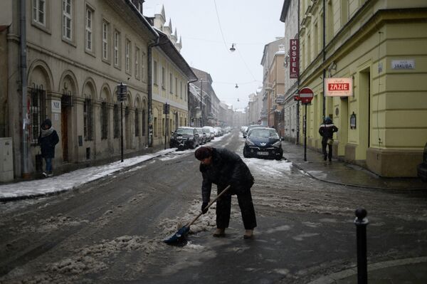Женщина очищает мостовую от снега. Архивное фото - Sputnik Таджикистан