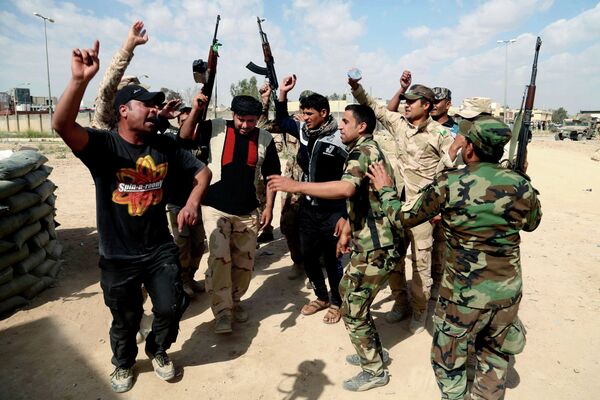 Иракские борцы на линии фронта выкрикивают лозунги против боевиков ИГ. Город Тикрит. - Sputnik Таджикистан