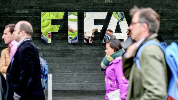 Люди идут мимо здания Международной федерации футбола (ФИФА) в Цюрихе. Архивное фото - Sputnik Таджикистан