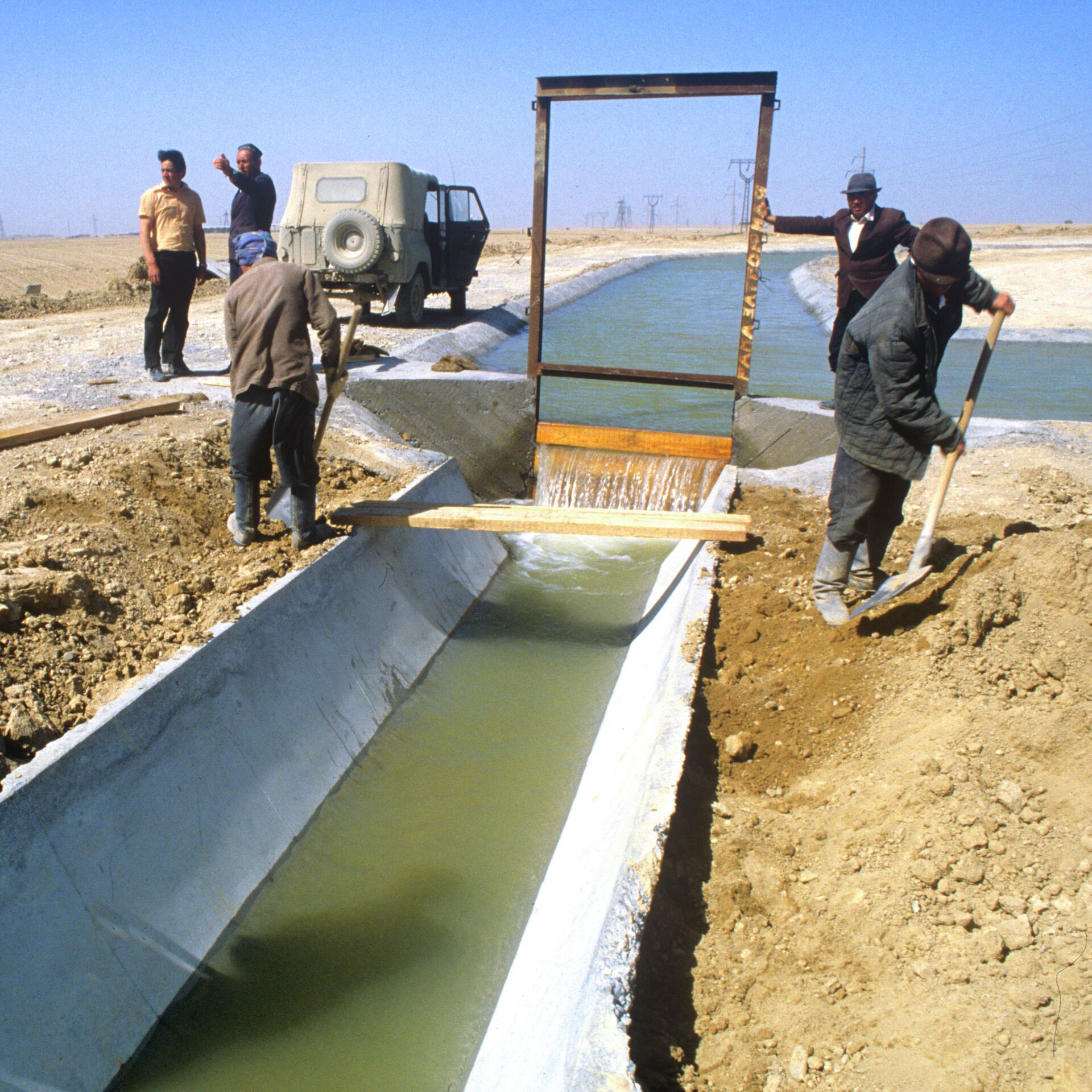 Люди перегородили реку большой. Оросительные каналы Узбекистана. Оросительные каналы в пустыне. Строительство оросительных каналов. Канал для орошения.
