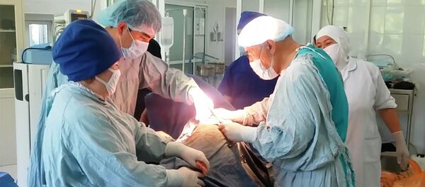 Табибон ҳангоми анҷом додани ҷарроҳӣ. Акс аз бойгонӣ - Sputnik Тоҷикистон