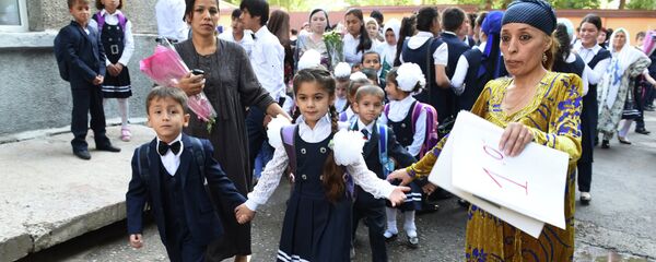 Учительница ведет первоклассников на первый урок в школе №16 города Душанбе. Учительница ведет первоклассников на первый урок в школе №16 города Душанбе. - Sputnik Таджикистан