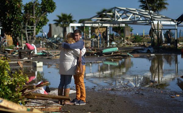 Люди обнимаются среди разрушений, причиненных землетрясением и цунами в Конконе, Чили. - Sputnik Таджикистан