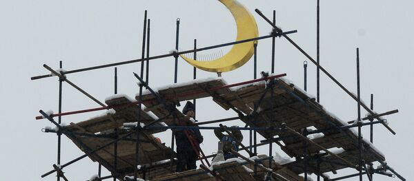 Рабочие устанавливают полумесяц на минарет Московской Соборной мечети. Архивное фото - Sputnik Таджикистан