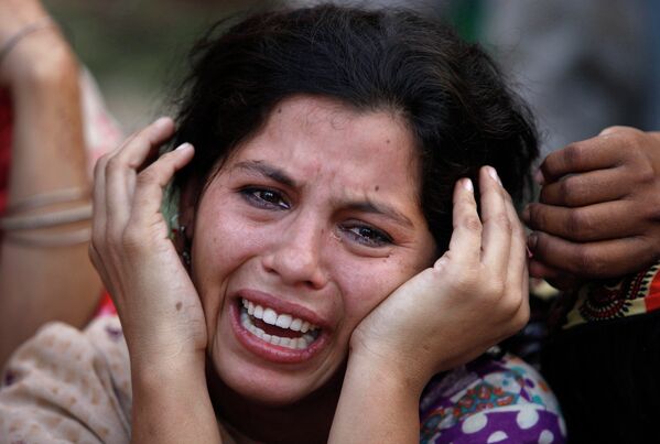 Женщина оплакивает дочь, погибшую во время схода оползня в городе Карачи (Пакистан) - Sputnik Таджикистан