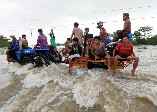 Филиппинцы проезжают на тракторе во время наводнения - Sputnik Таджикистан