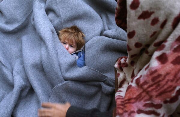 Ребенок, завернутый в одеяла во время отдыха мигрантов возле сербско-хорватской границы - Sputnik Таджикистан