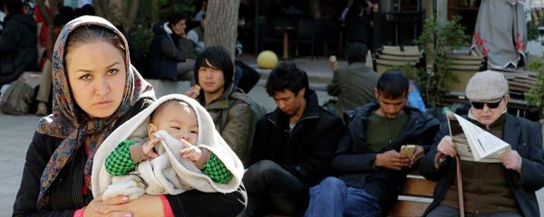 Женщина с ребенком стоит на площади Виктории в Афинах - Sputnik Таджикистан