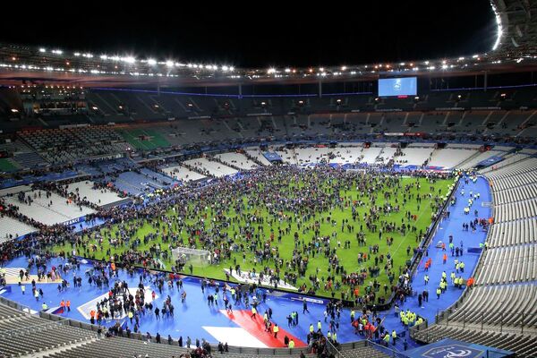 Люди во время эвакуации собрались в центре стадиона Stade de France, рядом с которым прогремели взрывы Люди во время эвакуации собрались в центре стадиона Stade de France, рядом с которым прогремели взрывы - Sputnik Таджикистан