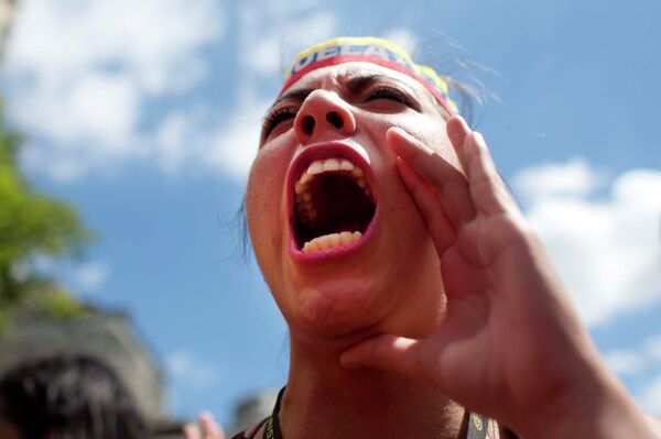 Студентка поет во время антиправительственного марша в Венесуэле, призывающего голосовать за Новую Венесуэлу в преддверии выборов в конгресс - Sputnik Таджикистан