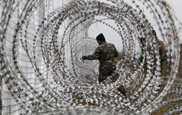 Македонский военнослужащий устанавливает забор с колючей проволокой на границе Македонии и Греции - Sputnik Таджикистан