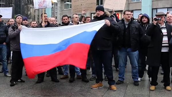 Кельнцы с флагами РФ вышли на митинг из-за инцидента с девочкой в Берлине - Sputnik Таджикистан