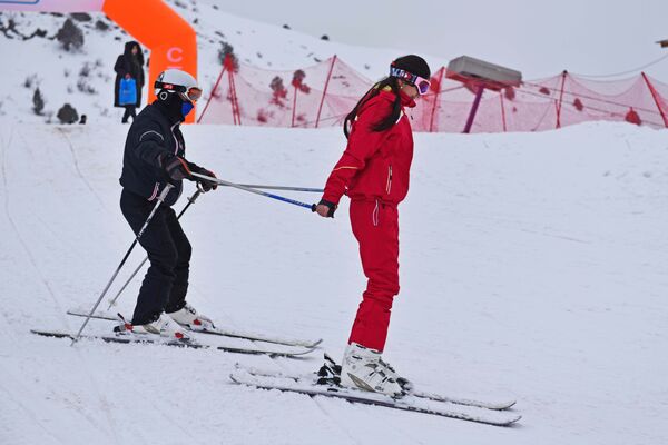 Инструктор учит отдыхающую кататься на лыжах в горнолыжном курорте Сафед Дара - Sputnik Таджикистан