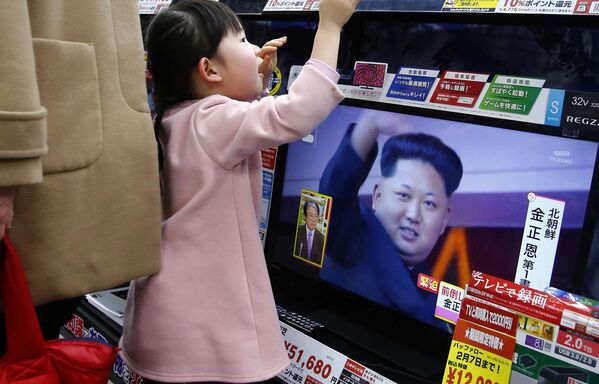 Девочка смотрит передачу с кадрами северокорейского лидера Ким Чен Ына в одном из магазинов Токио - Sputnik Таджикистан
