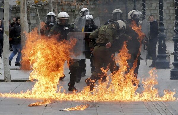 Полиция в Афинах уворачивается от зажигательных бомб во время массовых акций протеста против пенсионной реформы в Греции - Sputnik Таджикистан