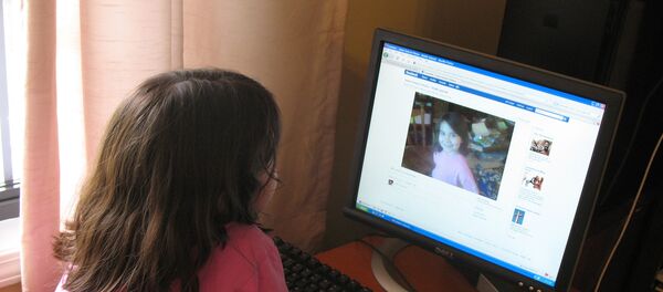 Девочка рассматривает фотографию в социальной сети Facebook. Архивное фото Девочка рассматривает фотографию в социальной сети Facebook. Архивное фото - Sputnik Таджикистан