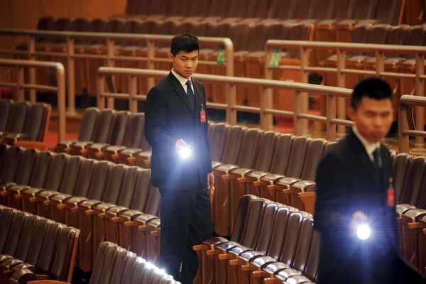 Офицеры безопасности осматривают зал после церемонии закрытия  Национального народного конгресса в Пекине - Sputnik Таджикистан