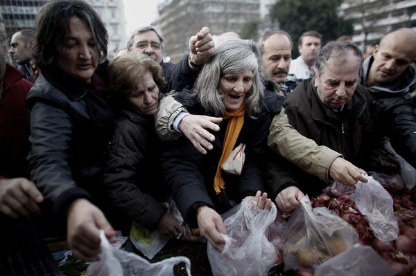 Люди пытаются получить еду, которая раздается греческими фермерами в Афинах во время акции протеста против пенсионной реформы. Архивное фото - Sputnik Таджикистан