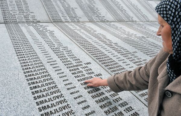 Женщина касается имени своего мужа на мемориале памяти погибшим в резне в Сребренице во время войны в Югославии 1991-1995 годов - Sputnik Таджикистан