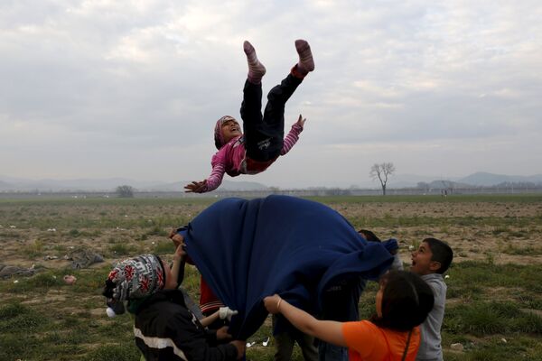 Дети играют в лагере беженцев возле греческого города Идомени на греческо-македонской границе - Sputnik Таджикистан