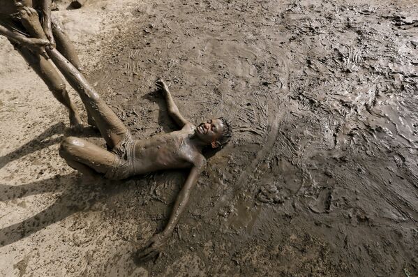 Дети играют в грязи, чтобы охладиться от жары в Нью Дели (Индия). В понедельник 4 апреля температура там достигала 38 градусов - Sputnik Таджикистан