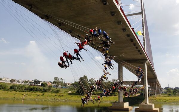 Люди прыгают с 30-метрового моста с веревкой (роапджампинг)в Хортоландии (Бразилия). По словам организаторов, новый мировой рекорд пытались установить 149 человек - Sputnik Таджикистан