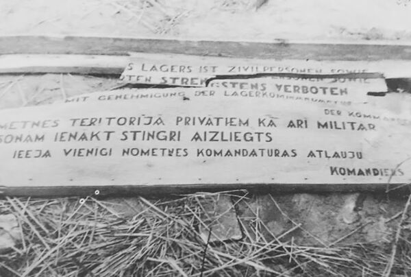 Табличка при входе в концентрационный лагерь Саласпилс (1944 год). Сброшена на землю во время прихода Советской армии. Табличка при входе в концентрационный лагерь Саласпилс (1944 год). Сброшена на землю во время прихода Советской армии. - Sputnik Таджикистан