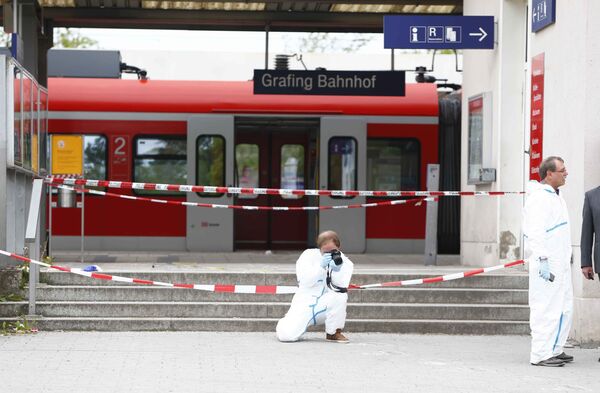 Полицейский делает фотографии на месте нападения на вокзале в Мюнхене, где были ранены пять человек - Sputnik Таджикистан