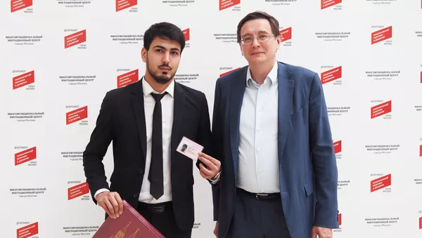 Дорандаи 600 ҳазорумин патент-Ҳакимҷон Раҳматов (аз тарафи чап) бо директори генерали маркази муҳоҷирати меҳнатӣ Николай Фидосеев.Акс аз бойгонӣ - Sputnik Тоҷикистон