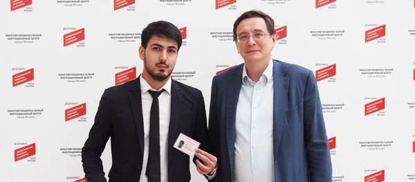 Дорандаи 600 ҳазорумин патент-Ҳакимҷон Раҳматов (аз тарафи чап) бо директори генерали маркази муҳоҷирати меҳнатӣ Николай Фидосеев.Акс аз бойгонӣ - Sputnik Тоҷикистон