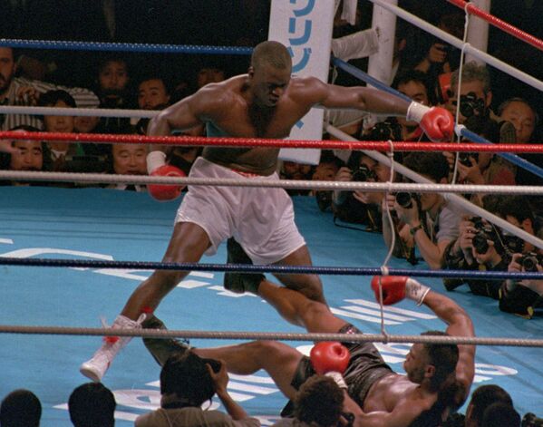 Боксер Майк Тайсон лежит на ринге после удара Бастера Дагласа. Архивное фото - Sputnik Таджикистан