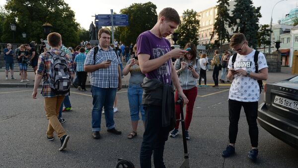 Игроки в Pokemon Go в Ильинском сквере в Москве - Sputnik Таджикистан