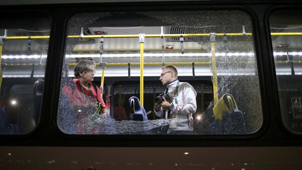 Разбитое окно автобуса, в котором находились журналисты, подвергся нападению в Рио - Sputnik Таджикистан