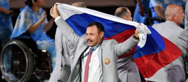 Представитель паралимпийской сборной Белоруссии с флагом России во время парада атлетов и членов национальных делегаций на церемонии открытия XV летних Паралимпийских игр 2016 в Рио-де-Жанейро. - Sputnik Таджикистан