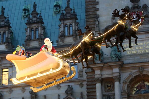 Немецкий Санта-Клаус на центральной площади Гамбурга во время специальной рождественской инсталляции - Sputnik Таджикистан