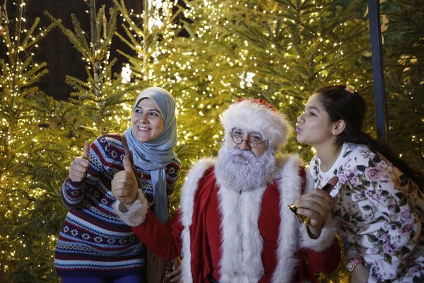 Ливанские девушки фотографируются с Санта-Клаусом в центре Бейрута - Sputnik Таджикистан