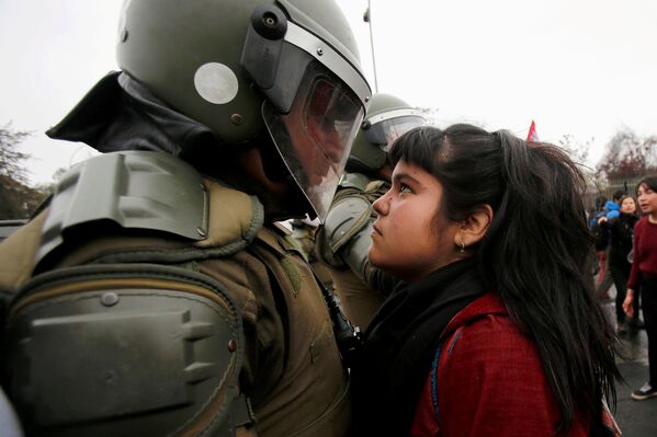 Девушка и полицейский во время акций протеста в Сантьяго, Чили - Sputnik Таджикистан