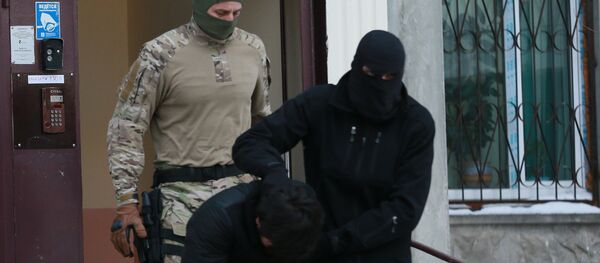 Силовики выводят из подъезда дома  одного из участников диверсионно-террористической группы - Sputnik Таджикистан
