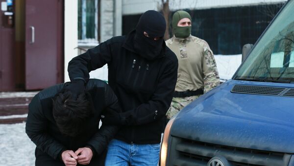 Силовики выводят из подъезда дома одного из участников диверсионно-террористической группы - Sputnik Таджикистан