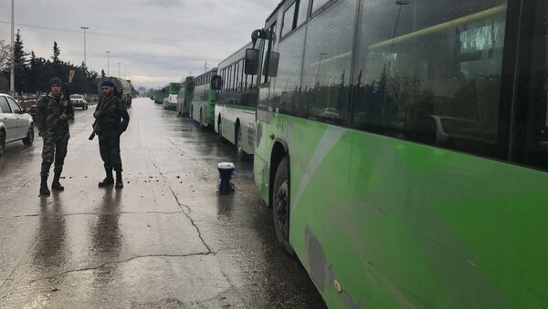 Автобусы в ожидании выхода боевиков в квартале Салахеддин у Юго-западного выезда из сирийского Алеппо - Sputnik Таджикистан