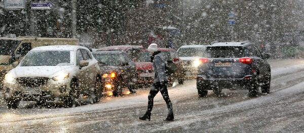 Женщина переходит улицу во время снегопада - Sputnik Таджикистан