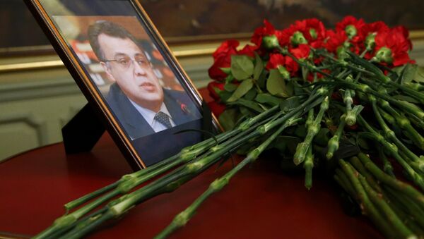 Цветы возле фотографии погибшего посла РФ в Турции Андрея Карлова - Sputnik Таджикистан